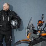 Man som bär MC-kläder och står bredvid en MC